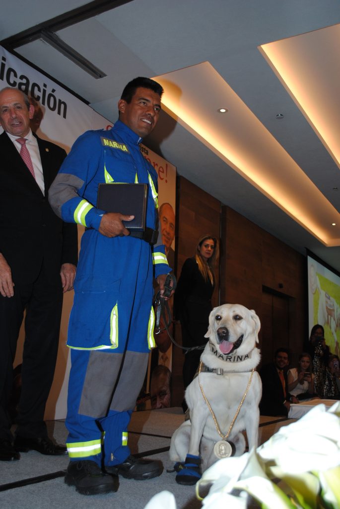 La perrita Frida y su entrenador Israel Arauz Salinas, recibieron una medalla de honor con la imagen de José Pagés Llergo